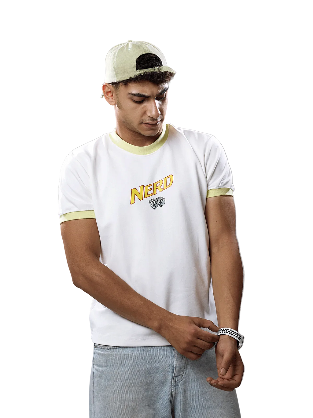 A man wearing a white t-shirt with yellow-green trim and a 'NERD' graphic on the chest, paired with a light beige cap and light blue jeans, standing against a solid gray background.