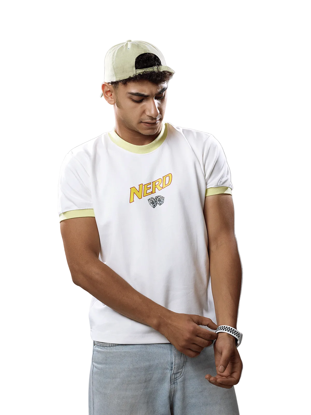 A man wearing a white t-shirt with yellow-green trim and a 'NERD' graphic on the chest, paired with a light beige cap and light blue jeans, standing against a solid gray background.