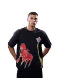 A man wearing a black short-sleeve t-shirt with a large red dripping graphic on the front and a yellow street lamp graphic, posed against a solid gray studio background.