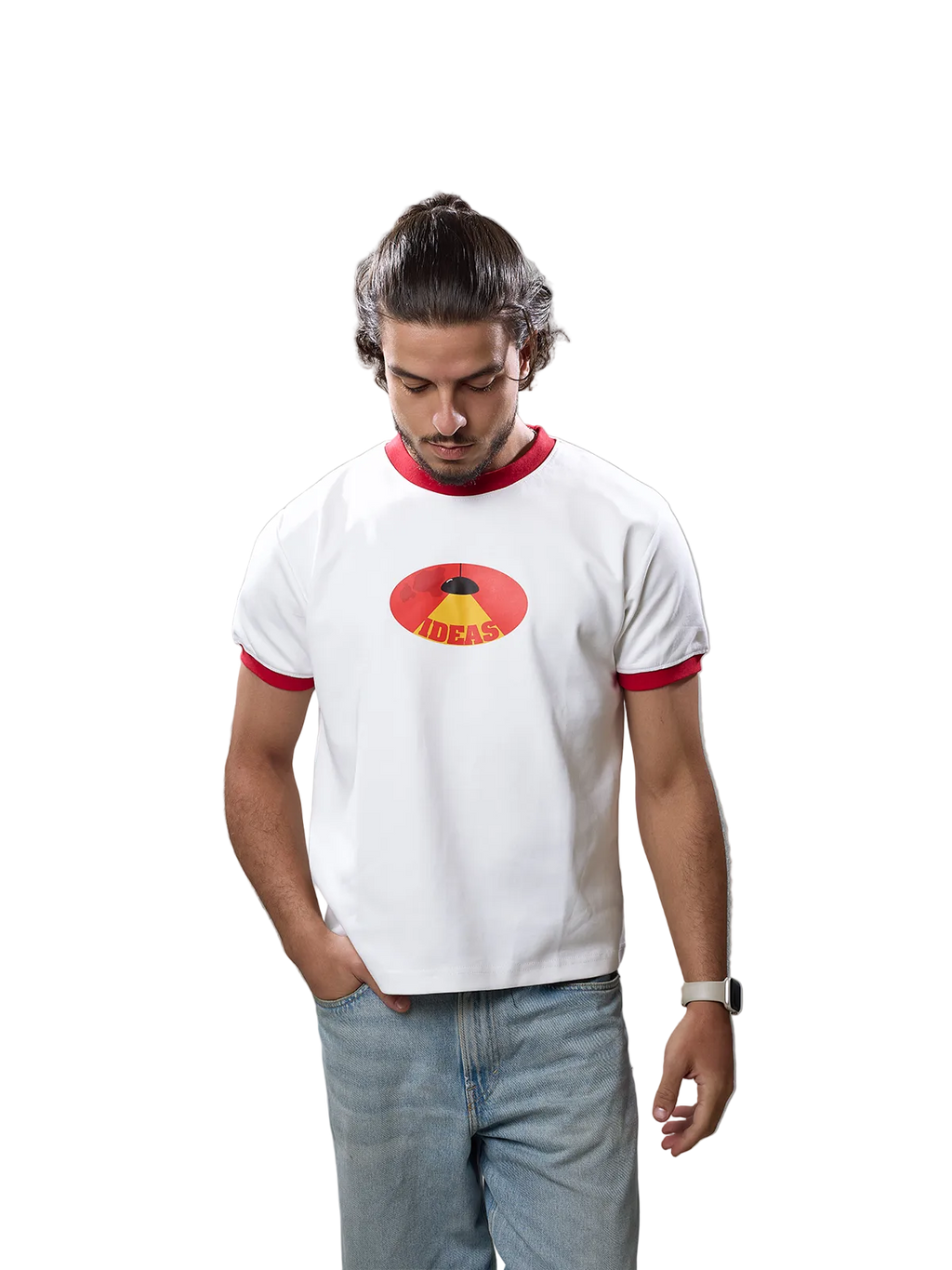 A man wearing a white ringer t-shirt with red trim and a red and yellow graphic on the chest, paired with light blue jeans, standing against a solid gray background.
